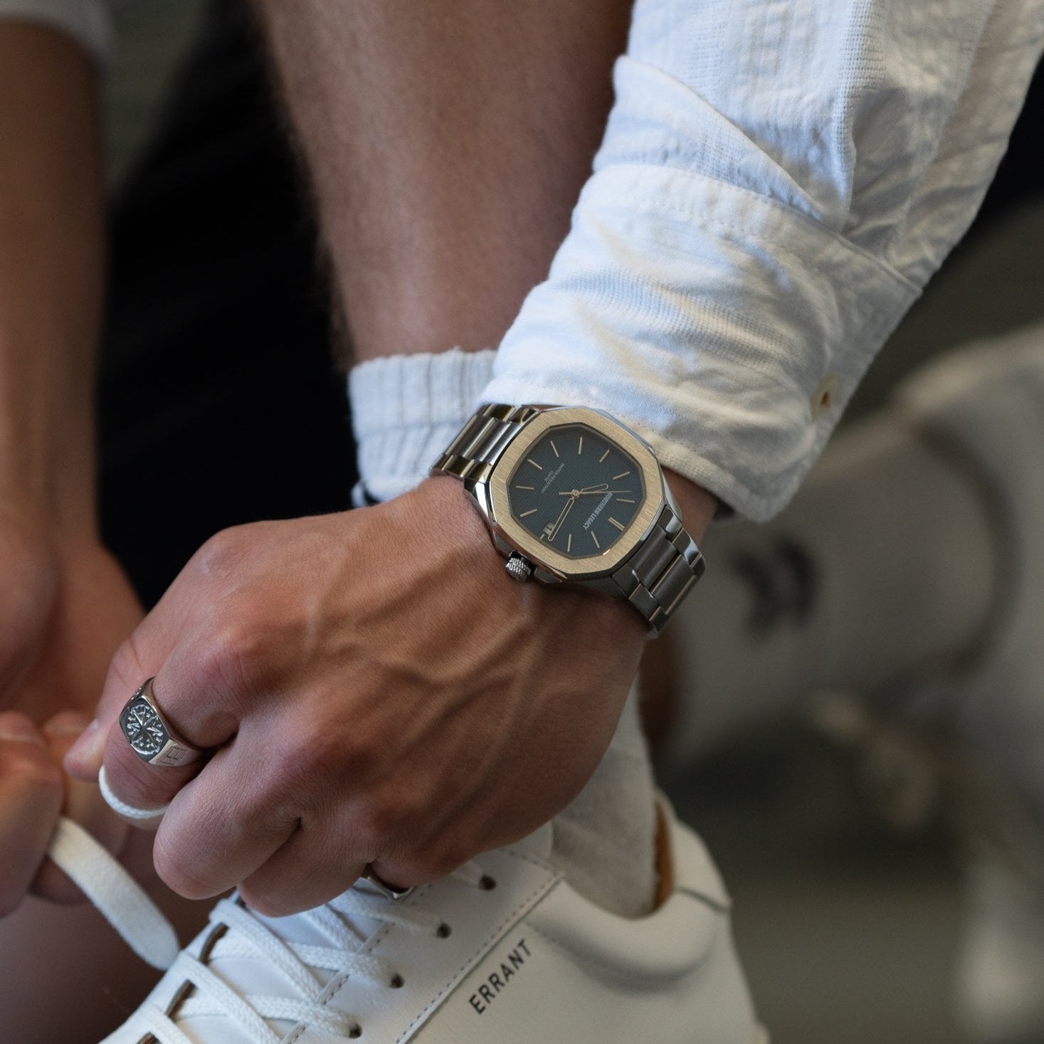 Mand binder snørebånd med Fjord ur - Blå og sølvring på håndleddet.